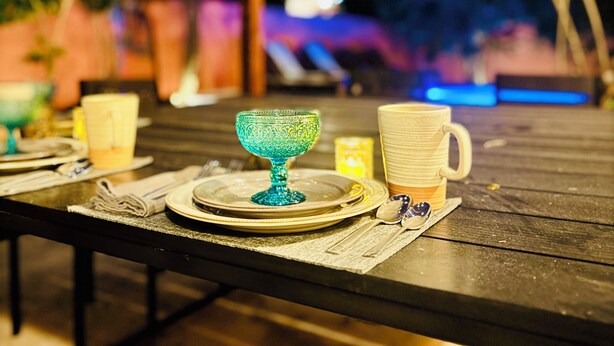 A table set outdoors with plates, a glass bowl, and cups. - Tropical Mid-Century Modern B&B in Merida's Centro, Azul (Mérida)