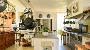 A spacious kitchen with a large island, hanging pots, and a rustic aesthetic. - Les Nymphéas, Landes haven of peace, nature & private pond (Angresse)