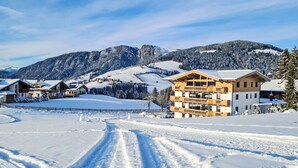 A snow-covered mountain resort with chalet-style buildings, a ski slope, and a clear sky. - Nice apartment for 5 people with WIFI, TV and balcony (Wildschönau)
