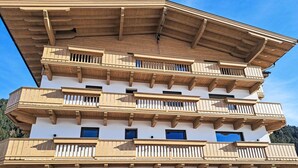 A multi-story building with wooden balconies and multiple windows. - Nice apartment for 5 people with WIFI, TV and balcony (Wildschönau)
