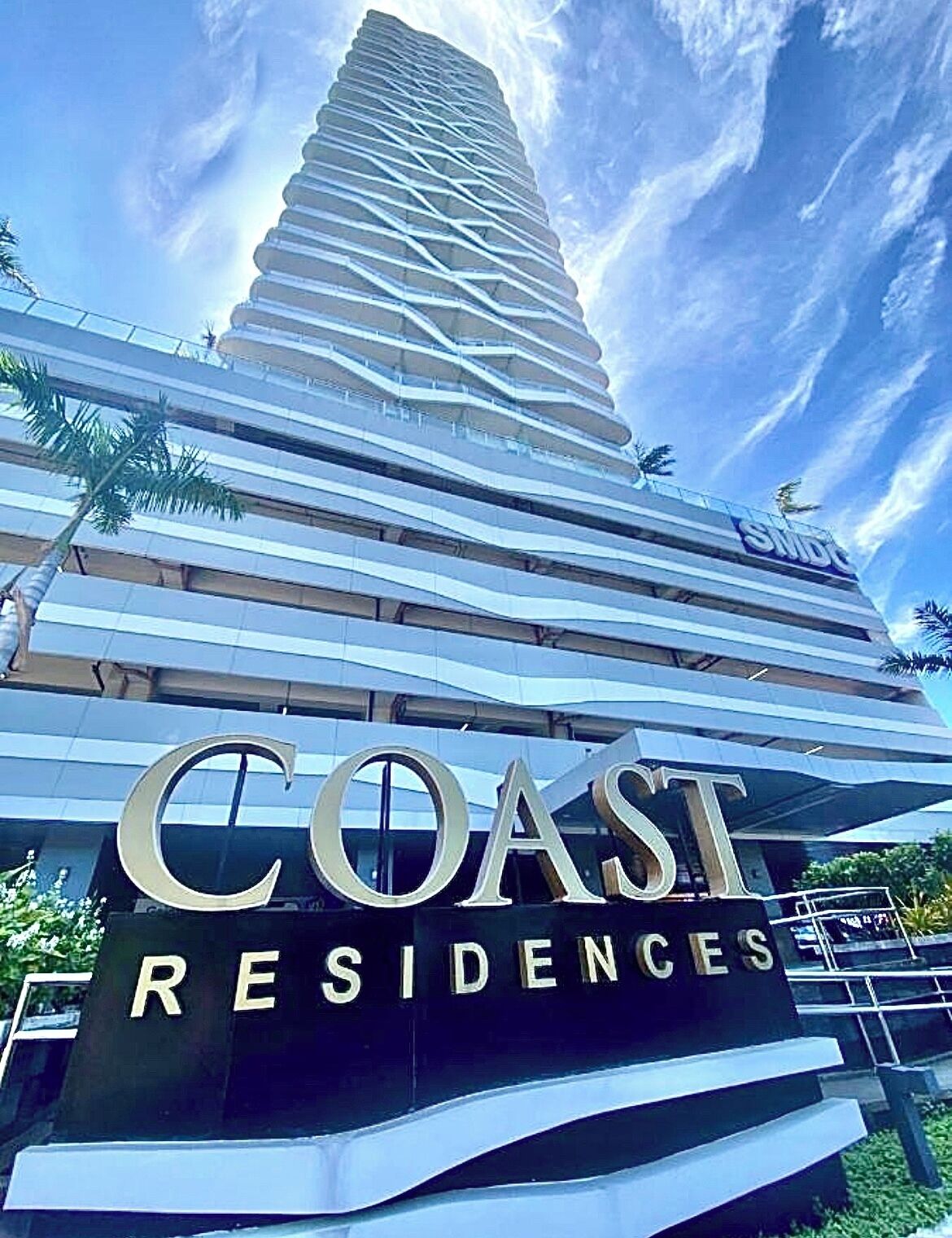 Ein modernes Gebäude mit einem auffälligen Schild, auf dem "COAST RESIDENCES" steht.