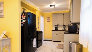 A kitchen with a black refrigerator, a coffee maker, and cabinets. - A stay at summers offers stunning water views from nearly every window. (Pictou, Subd. B)