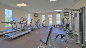 A gym with treadmills, elliptical machines, and weightlifting equipment.
