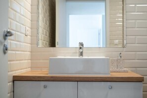 A bathroom with a white sink, wooden countertop, and a mirror above it. - Galanda 24 (Turcianske Teplice)