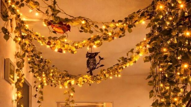 A hallway with a staircase, decorated with string lights and ivy. - Hotel El Encanto (Bogotá)