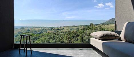 Una habitación con un ventanal que da a un paisaje montañoso.