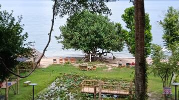 Un entorno tranquilo junto al lago, con una terraza de madera, sillones de descanso y un estanque con nenúfares.