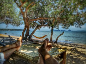 A wooden deck with a hammock, a beach view, and a tree providing shade. - Krabi Campsite Glamping & Camping (Krabi)