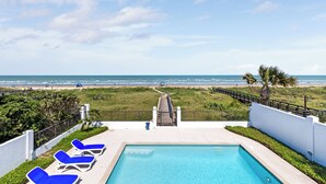 A pool area with a view of the beach, a pathway leading to the beach, and lounge chairs. - Luxury Beachfront Home w/ private beach access & private heated pool! (South Padre Island)