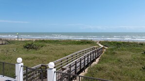 A wooden boardwalk leading to a beach with a clear view of the ocean. - Luxury Beachfront Home w/ private beach access & private heated pool! (South Padre Island)