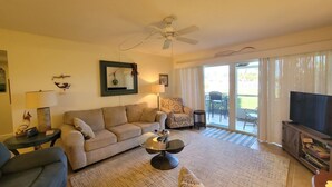 A living room with a sofa, armchair, coffee table, and a television. - CP 413 Dune View Condo - Welcome To Paradise! (Fort Pierce)