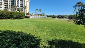 A well-maintained grassy area with a modern building in the background. - CP 413 Dune View Condo - Welcome To Paradise! (Fort Pierce)
