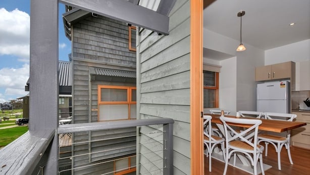 A modern kitchen with white cabinetry and a built-in oven. - The Chalet (Dinner Plain)