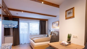 Ein gemütliches Schlafzimmer mit Bett, Schreibtisch und Fernseher.