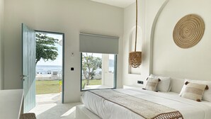 Een slaapkamer met een groot bed, uitzicht op zee en een wandkleed.