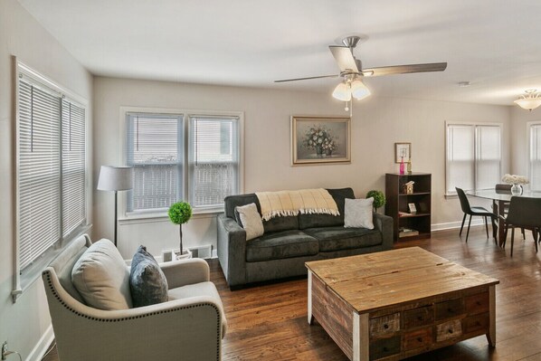 A living room with a sofa, armchair, coffee table, and a ceiling fan. - Home w/ 2 Kitchen & Living Rooms, Near Naval Base! (Libertyville)