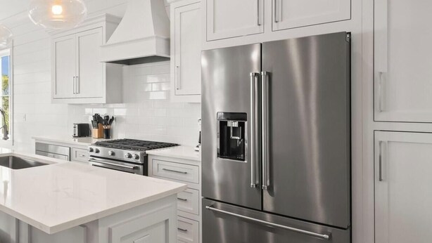 A modern kitchen with white cabinetry, stainless steel appliances, and pendant lighting. - The Osprey 12-Bayfront w/ boat slip, elevator, & pool. Sapphire Osprey by Kaiser (Orange Beach)