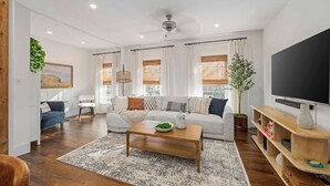 Ein modernes Wohnzimmer mit einer Couch, einem Couchtisch und einem Fernseher.