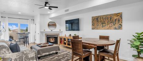 Uma sala de estar moderna com lareira, mesa de jantar e assentos confortáveis.