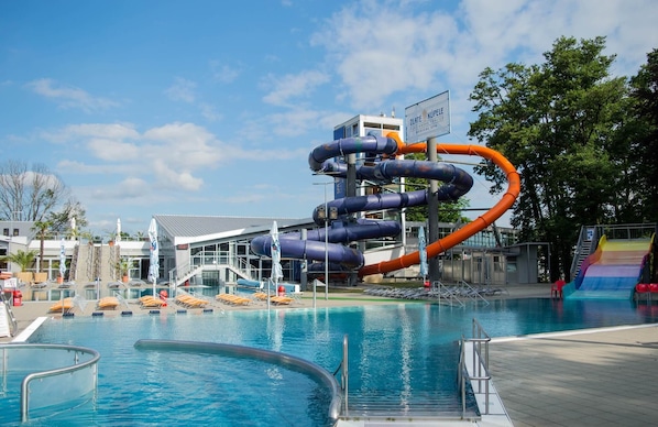 En vattenpark med en stor vattenrutschkana, en pool och en byggnad med en skylt.