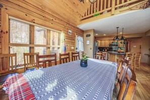 Ein Esszimmer aus Holz mit einem für sechs Personen gedeckten Tisch und umstehenden Holzstühlen.