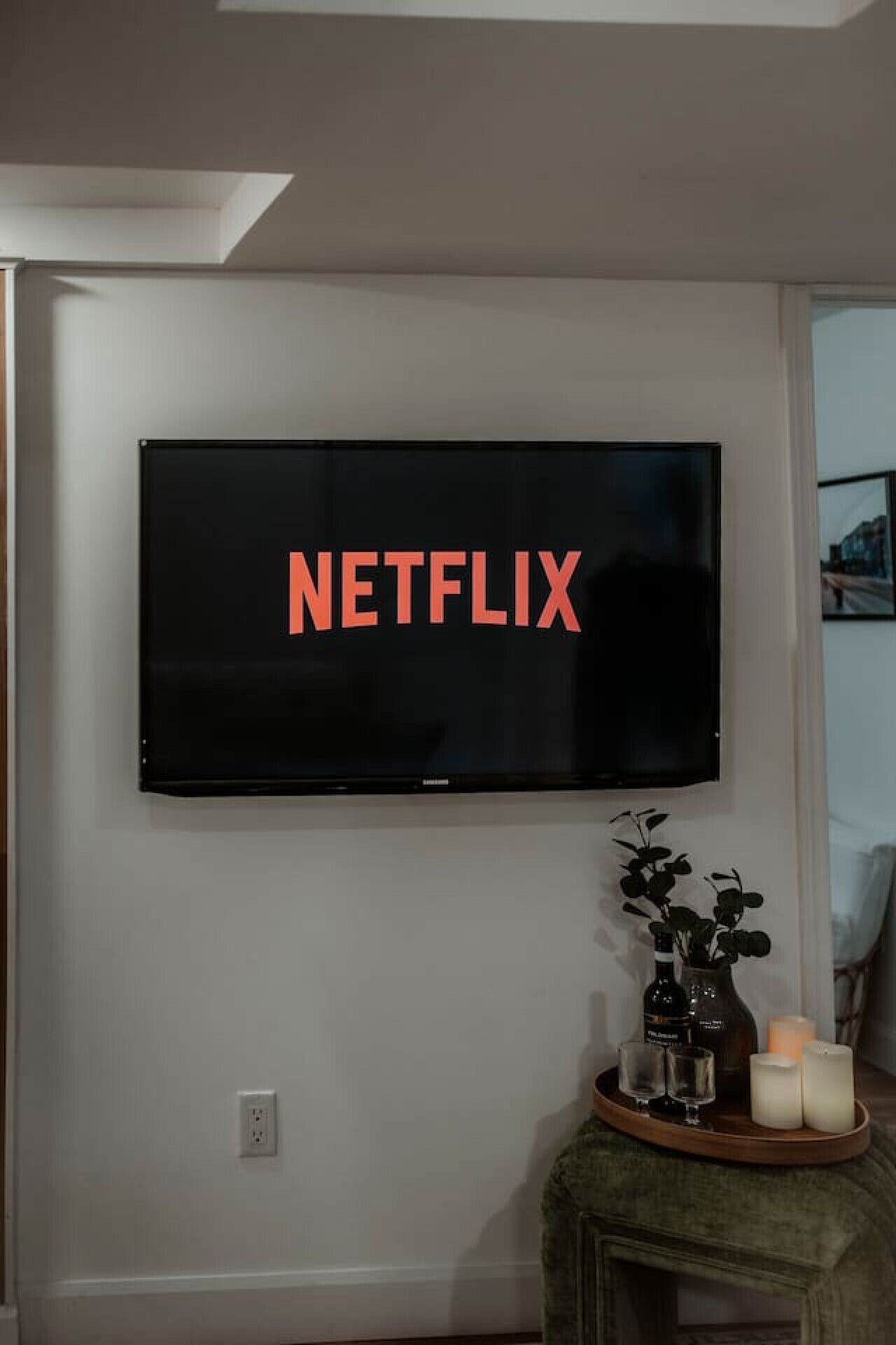 A wall-mounted television with the word "NETFLIX" displayed on the screen.