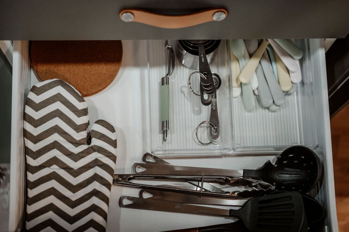 A drawer with various tools and a tie.