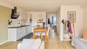 A modern apartment with a dining area, kitchenette, and a living room with a sofa and a bed. - Nimma Garden one bedroom apartment (Nijmegen)