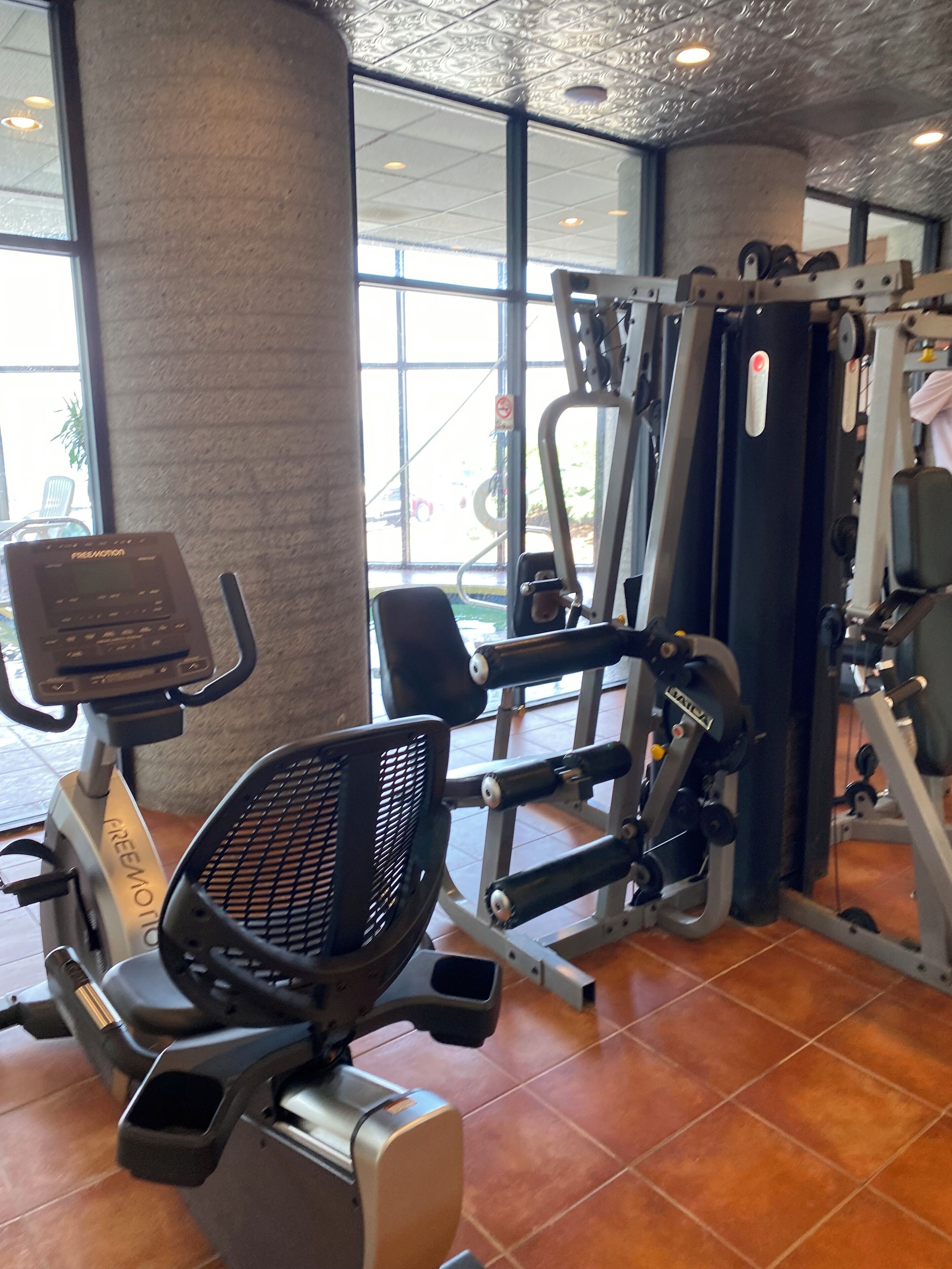 A gym with cardio equipment, weight machines, and a mirror.