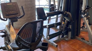 A gym with cardio equipment, weight machines, and a mirror. - Charming 2-bedroom condo with fitness room and WiFi in fabulous Sugar Mountain (Sugar Mountain)