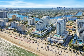 A coastal cityscape with high-rise hotels, a beach, and a marina.