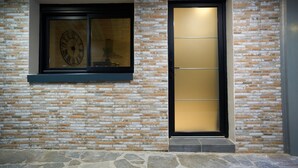 Une façade de bâtiment moderne, avec un motif en briques et une grande porte vitrée.
