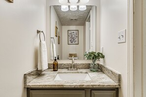 A bathroom with a marble sink, a mirror, a framed picture on the wall, and a potted plant. - 9 Mi to Dtwn Indianapolis: Family-Friendly Home! (Indianapolis)