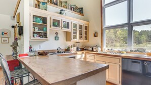 Une cuisine dotée d’un grand îlot central, de meubles en bois et d’un lave-vaisselle.