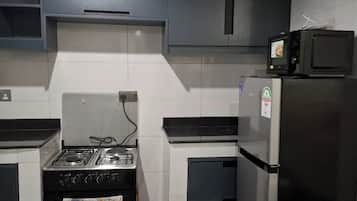 Appartement Familial, vue ville | Cuisine privée | Réfrigérateur, micro-ondes, batterie de cuisine, vaisselle et ustensiles