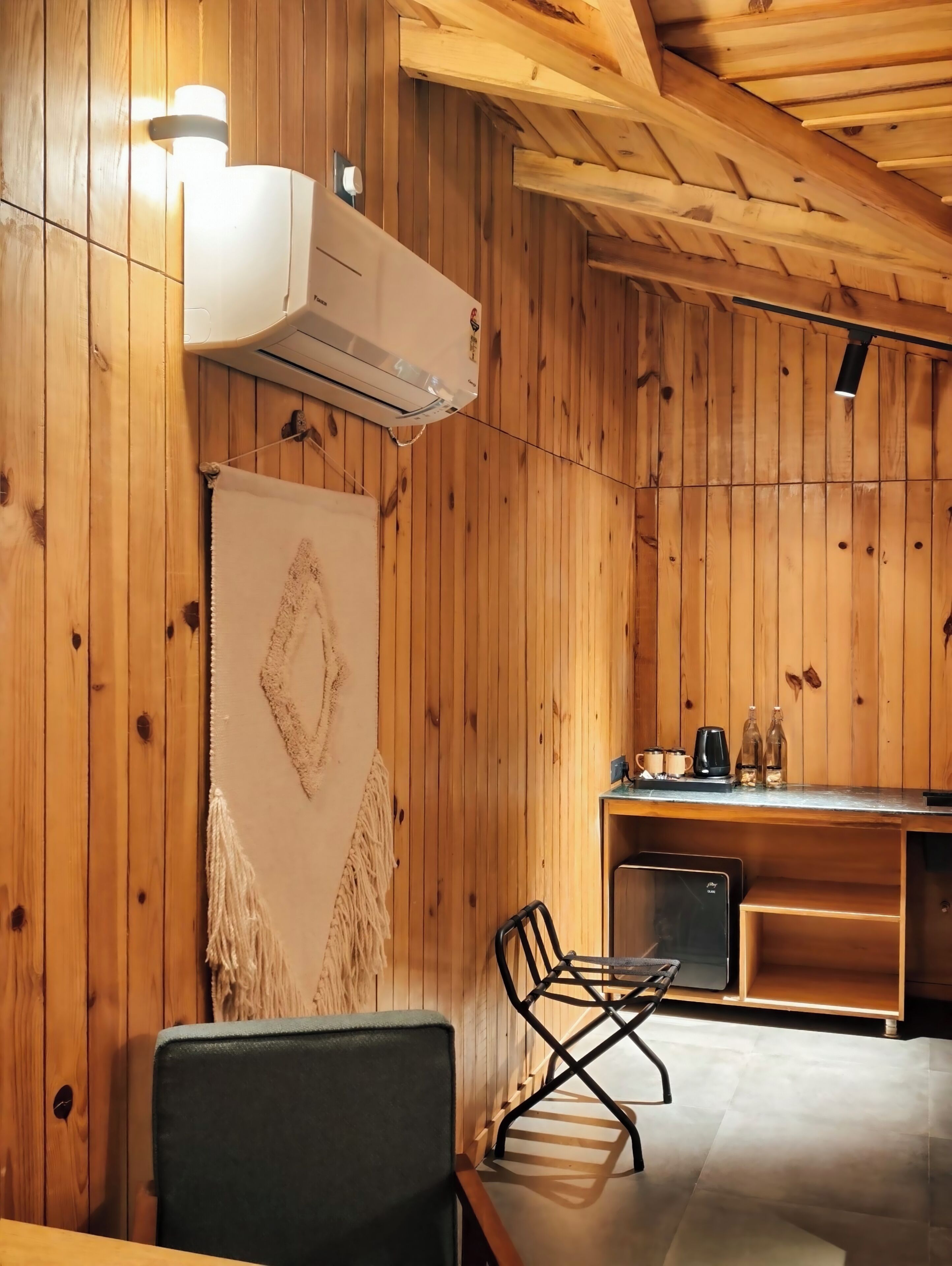 A wooden interior with a dining area, a kitchen, and an air conditioning unit.