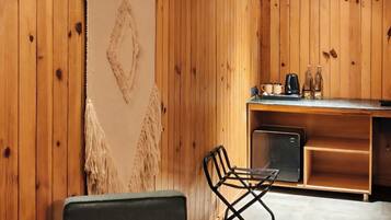 A wooden interior with a dining area, a kitchen, and an air conditioning unit.
