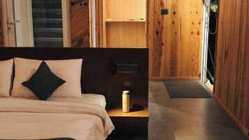 A bedroom with a bed, bedside table, and a wooden wardrobe.