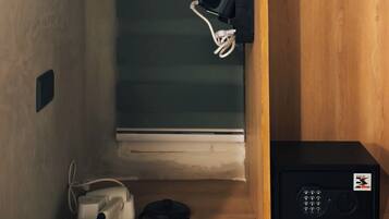 Una habitación con un armario de madera, un dispositivo electrónico negro y un aparato blanco en el suelo.