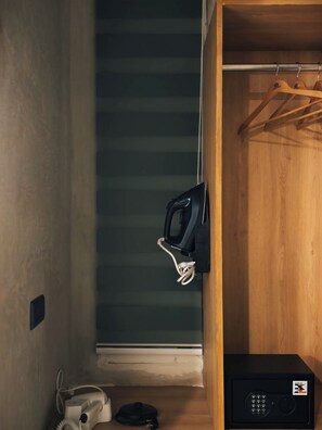 Ein Zimmer mit einem Holzkoffer, einem schwarzen elektronischen Gerät und einem weißen Gerät auf dem Boden.