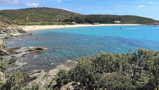 A coastal landscape with clear blue waters, sandy beach, and a hilly backdrop. - Villa Céleste, Apartment in villa, Swimming pool, garden, quiet, near the sea (Cavalaire-sur-Mer)