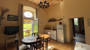 A kitchen with a dining table, chairs, a refrigerator, and a window with curtains. - Merula. Organic winery farm between Orvieto and Lake Bolsena (orvieto)
