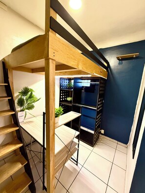 A modern kitchen with a built-in refrigerator, wooden shelving, and a staircase leading to an upper level. - Urban Rooms - Hostel (Mexico City)