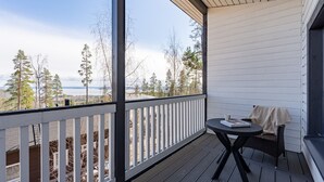 A covered balcony with a view of trees and a body of water. - Spacious & Cozy 2BR Cabin at Riihivuori Peak next to Ski Slopes (Muurame)