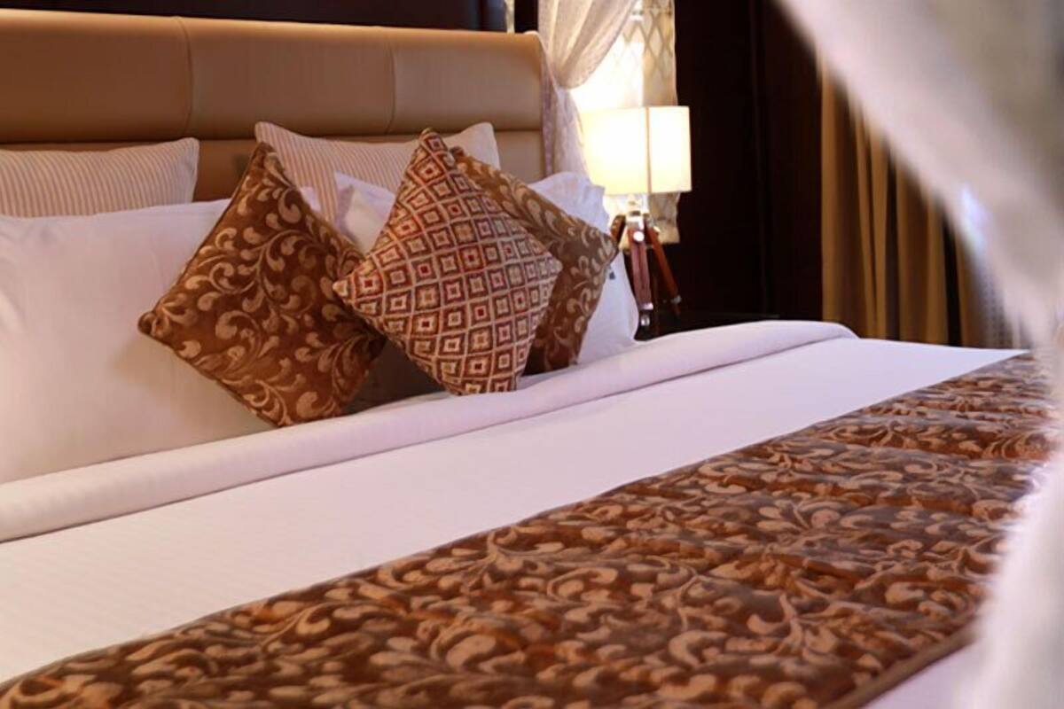 Un lit bien fait, agrémenté d’oreillers à motifs et d’une couvre-lit décorative.