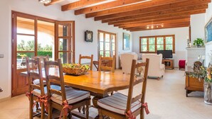 A dining area with a wooden table and chairs, a television, and a fireplace.