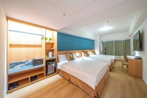 Une chambre d’hôtel avec deux lits, un bureau, une télévision et une armoire.