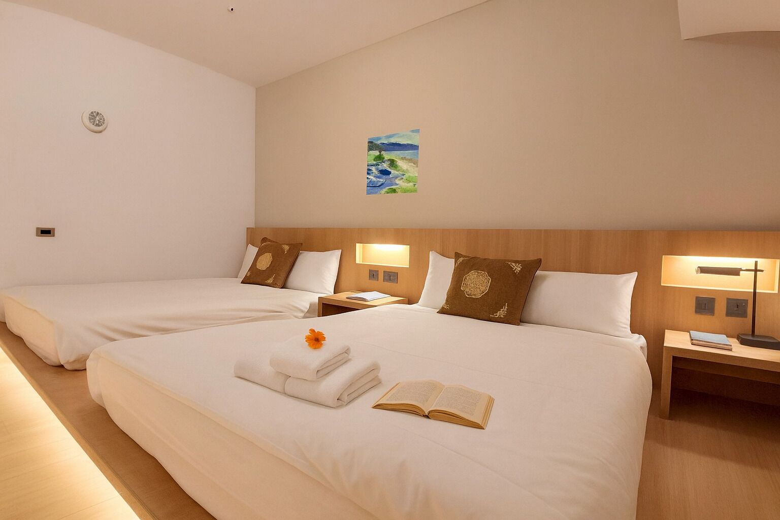 A hotel room with two beds, a painting on the wall, and a nightstand with a lamp.