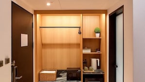 Une pièce compacte dotée d’une armoire intégrée, d’une petite kitchenette et d’un coin salon.