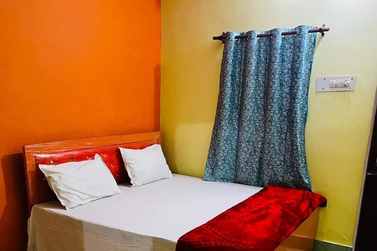 Uma cama com cabeceira vermelha, roupa de cama branca e um cobertor vermelho.